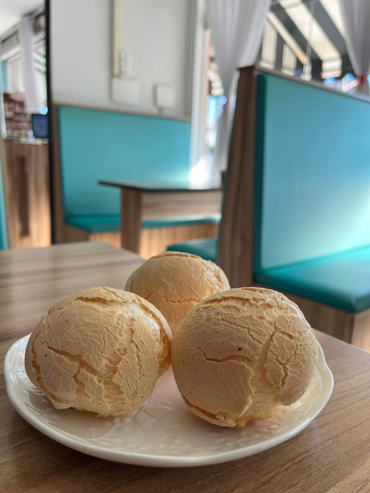 Três pães de queijo sobre um prato