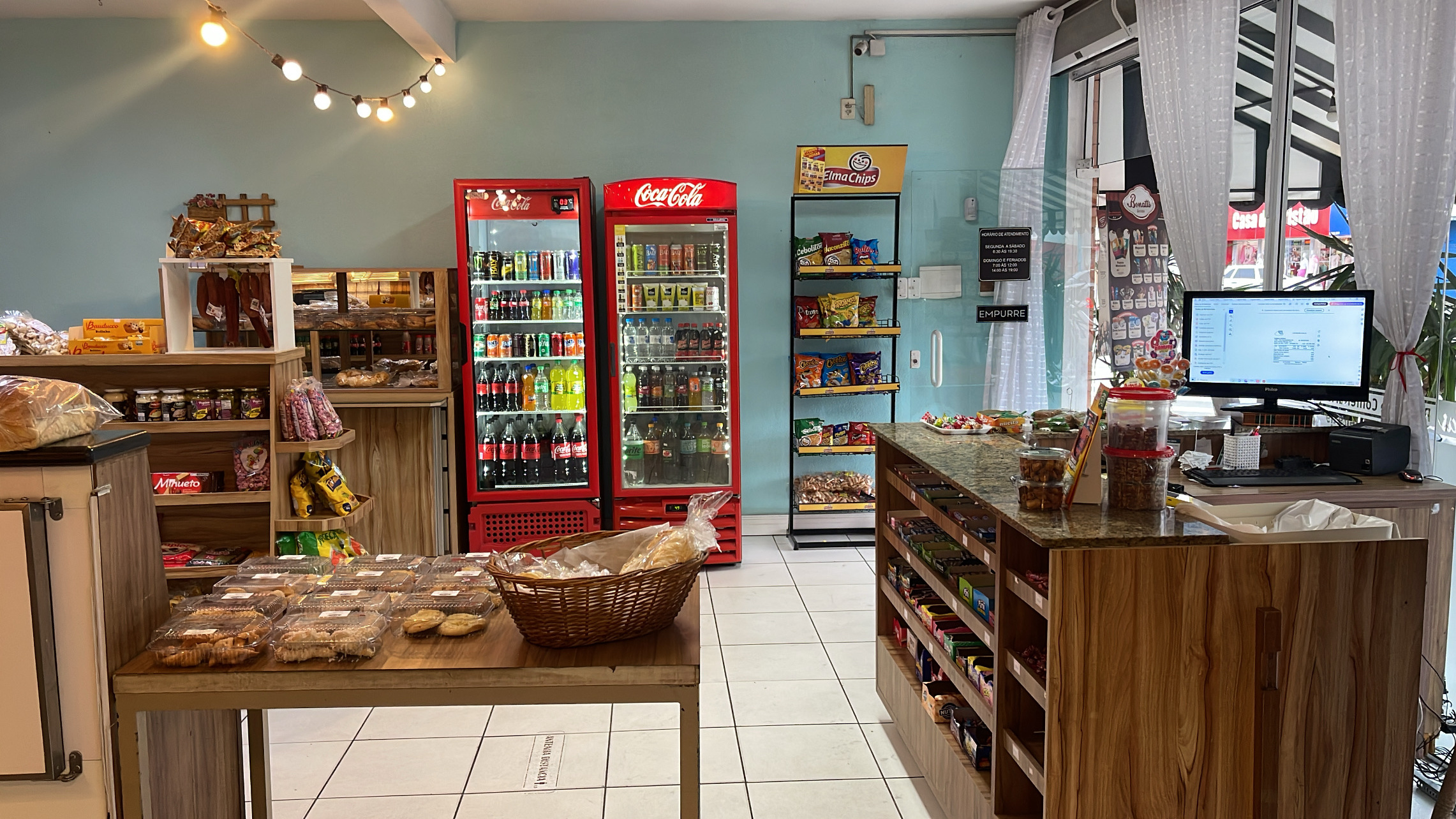 Interior da Biribas com vitrine, bebidas e balcão